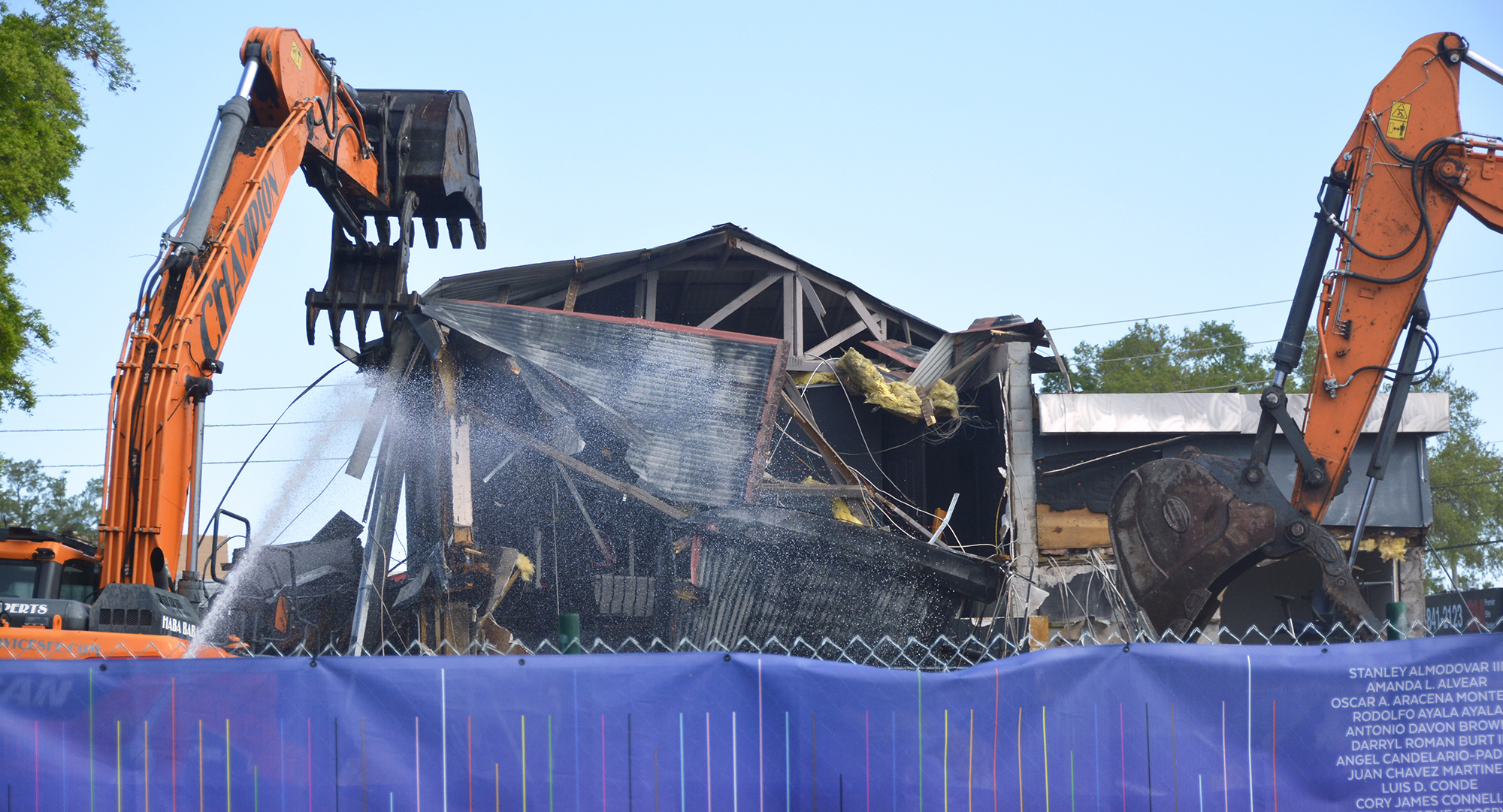 Heavy equipment tears down the walls of a building.